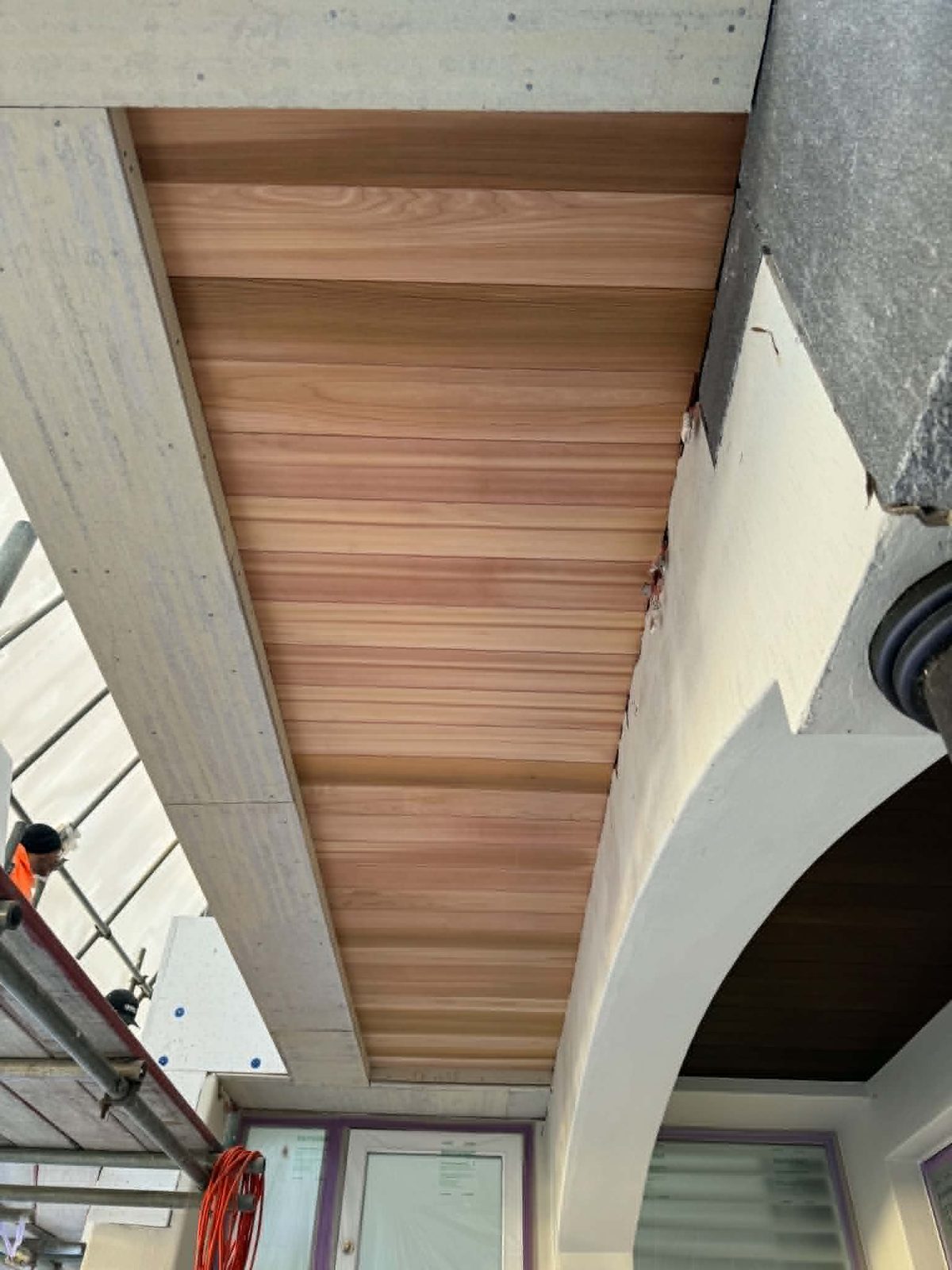 Finished alfresco ceiling lined in stained cedar boards
